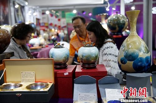 资料图：在哈尔滨举行的第六届中国-俄罗斯博览会上，参观者挑选台湾陶瓷工艺品。/p中新社记者 吕品 摄